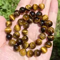 Primo piano di perle tonde in occhio di tigre marrone dorato con una trama naturale - 4mm (84-90 pezzi) / Occhio di Tigre Giallo