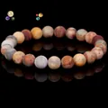 Natural round multicolor jasper stone bead bracelet on a reflective black background - Crazy Lace Agate