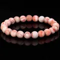 Natural stone beaded bracelet with orange veins on a reflective black background - Red Network Stone