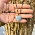 Primo piano di un ciondolo a cuore in pietra angelica con bordo dorato su cordino. - Stile Cuore / Cuore Oro