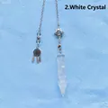 Detailed view of a clear quartz crystal pendulum with star and dreamcatcher charms. - Clear Quartz Arrowhead Pendulum