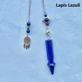 Detailed view of a blue lapis lazuli crystal pendulum with a star and dreamcatcher charm. - Lapis Lazuli Arrowhead Pendulum