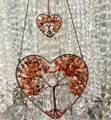 Detailed macro view of handmade orange heart tree of life crystal stone hanging ornament. - Red Agate