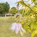Dettaglio di un acchiappasogni rosa albero della vita con piume viola e cristalli. - Ametista Chiara