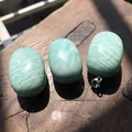 Primo piano di pietre naturali a forma di caramella con finitura lucida e gancio. - Amazzonite