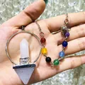 Detailed macro view of a rose quartz hexagonal pillar pendulum with seven colorful chakra beads - Natural / White Crystal