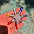 Detailansicht von sieben Chakra-Heilkristallsteinen im sternförmigen Design in der Hand - Chakra Weißer Quarz