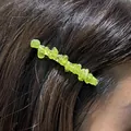 Dettaglio ravvicinato di un fermaglio per capelli con scaglie di cristallo verde. - Peridoto