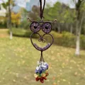 Macro view of wire-wrapped owl detail with colorful chakra stones in natural lighting. - Purple Crystal
