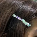 Handmade hair clip featuring irregular natural colorful crystal stones worn on brown hair - Green Fluorite