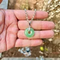 Dettaglio di un ciondolo donut in pietra naturale verde su catena a maglie color argento. - Avventurina (Ciondolo Solo)