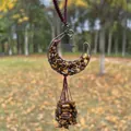 Macro view of handmade copper wire moon pendant filled with natural Tiger's Eye stones - Tiger's Eye