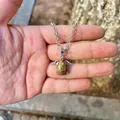 Detailed macro view of a silver angel wing natural stone pendant necklace held in palm - Pendant Only (No Chain) / Unakite