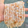Detail shot of peach and white natural stone round beads for DIY jewelry - Pink Aventurine