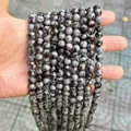 Detailed macro view of snowflake obsidian round loose beads for DIY jewelry making accessories. - Snowflake