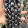 Dettaglio ravvicinato della trama liscia delle perle ovali in pietra naturale nera DIY - Ossidiana