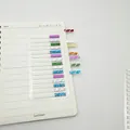 Detailed view of colorful laser index stickers applied to a notebook page - Short Blue Purple / 15 Pieces