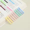 Close-up of Morandi color arrow index stickers on a book page for reading notes - Macarons