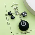 Detail view of a black 8-ball and cherry resin keychain with star clasp, length 10.2cm. - Black Cherry Black Dice Star Style (ER1621)