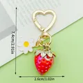 Cute strawberry keychain featuring a white daisy charm and a golden heart-shaped clasp - Colorful Solid Strawberry Style (LS616)
