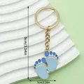Detailed size view of blue baby footprints keychain on a white decorative wave - Blue Feet Style (ER1512)