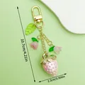 Detailansicht des Erdbeer-Schlüsselanhängers mit exakten Maßen von 10,7 cm x 2,3 cm - Gold Rosa Erdbeere Maiglöckchen Blatt Stil (ER1632)