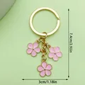 Elegant gold-tone keychain featuring three pink enamel flower charms with dimensions - Triple Flower Charm (LS232) / Pink
