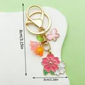 Detailed view of pink cherry blossom and butterfly metal keychain with size dimensions - ER1634 / Gold Pink Cherry Blossom Lily Butterfly
