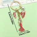Llavero de moda con vestido de esmalte rojo, tacón alto y sombrero, acabado dorado - Estilo de Modelo de Vestido Rojo (ER907)