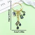 Gold finish vintage music themed keychain with note and guitar charms, size 8.1cm x 3cm - Piano Violin Style (ER2200) / Black