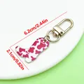 Pink cow print cowboy boot keychain with golden hardware and size measurements. - Western Cowboy Boot Style (ER2276) / 2.1x6.2cm (4.5g) / Rose Red