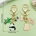 Leuke cartoon panda en bamboe metalen sleutelhanger met afmetingen in goudkleur. - Zijdelings Liggende Panda (ER1203)