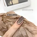 Maillard amber cat-eye magnetic nail gel polish in shade N.05 on brown paper prop - No.05