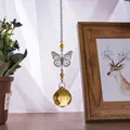 Detailed macro view of a faceted golden crystal ball pendant with a metal butterfly - Butterfly Suncatcher / Gold