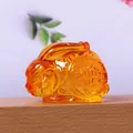 Macro-opname van amberkleurig glazen konijnenbeeldje met traditionele Fu-gravure - Gouden Amber Konijn