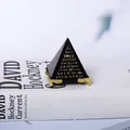 Vista dettagliata di un ornamento a piramide nera con base dorata e scritte - 6cm Piramide di Scrittura Nera