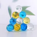 A detailed view of blue and yellow crystal glass spheres stacked in a pyramid shape - Colorful Spheres Ornament - Triangle