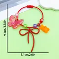 Detailed view of red cord bag charm with resin bear, pink butterfly and bow knot - Fancy Butterfly Bowknot Bear Letter Bead Keychain (ER2091)