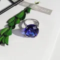 Macro view of a large blue faceted crystal ring ornament on a white decorative paper setting - 20mm Napkin Ring / Blue