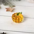 Nahaufnahme eines handgefertigten Kürbisses aus bernsteinfarbenem Glas auf Holzfläche - Kürbisform / 50*48mm / Gelb