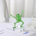 Detailed view of a green glass kung fu frog figurine ornament on a clear base - Kung Fu Frog with Base Hands Raised High