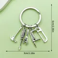 Detailed view of silver tool keychain charms with measurements showing 6cm by 3cm size - Saw Hammer Drill Tools Style (LS216)