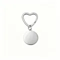 Detailed view of polished stainless steel circular tag and heart-shaped keychain ring - Steel