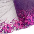Close-up detailed view of colorful floral embroidery on purple tulle lace trim for DIY - Colorful
