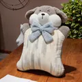 Vista detallada de un cojín de peluche de perro con un gran lazo azul sobre madera - Cojín (55*39cm) / Azul