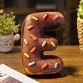 Suave cojín de peluche con forma de dónat de chocolate letra E y fideos de colores - Letra E (Colgante) / 10cm