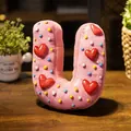 Cojín de peluche con letra U rosa estilo donut con corazones y detalles para cuarto de niños - Letra U (Colante) / 10cm