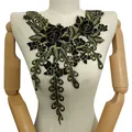 Vue détaillée d'un col en dentelle brodée noir et or aux motifs floraux sur mannequin - Or