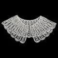Macro view of white cord embroidered lace doll collar detail on black background - L / White