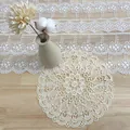 Detalle del bordado de un mantel individual redondo de encaje beige - Estilo Iris